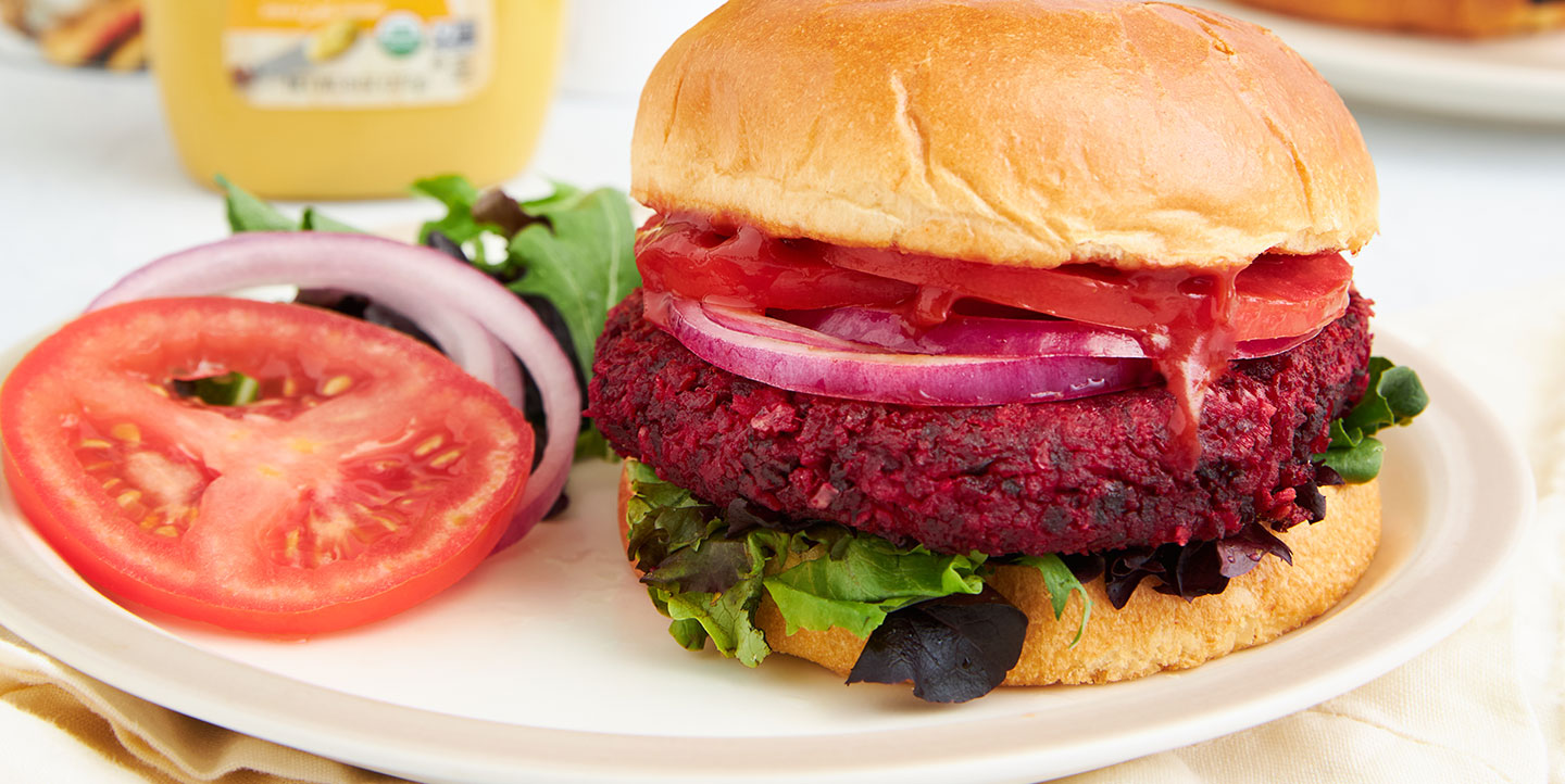 veggie burger topped with tomatoes, onion and lettuce on a bun