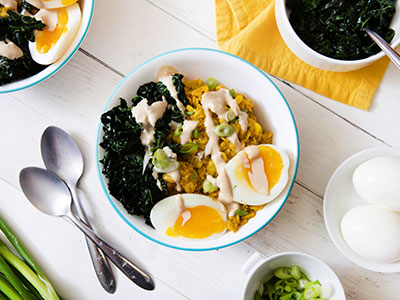 oatmeal, kale, and medium boiled egg in a bowl on a white table top