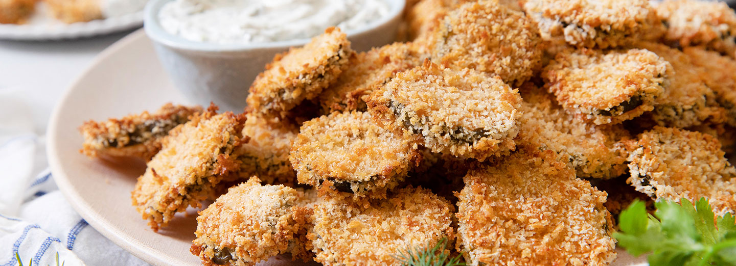 fried pickles on a plate with homemade ranch on side