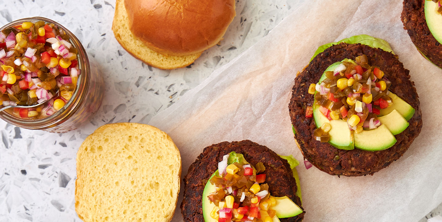 black bean burger on bun topped with avocado